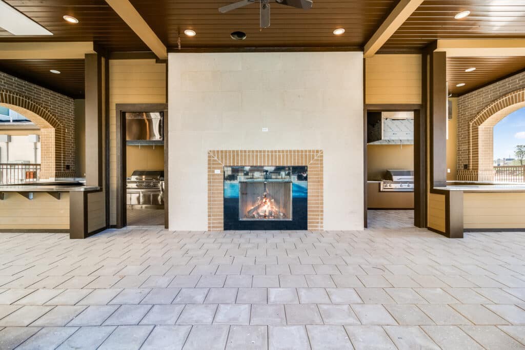 A modern living room with a central fireplace, surrounded by elegant decor and warm lighting.