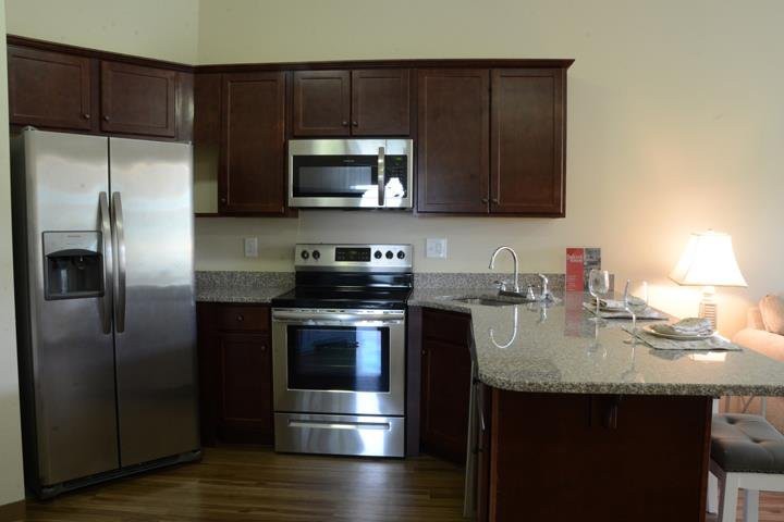 A modern kitchen with stainless steel appliances and wooden cabinets.