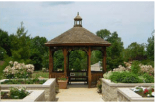 A wooden gazebo surrounded by a garden pathway.