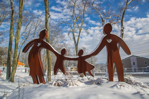 A family-themed sculpture stands gracefully in the snowy landscape, symbolizing unity and togetherness.