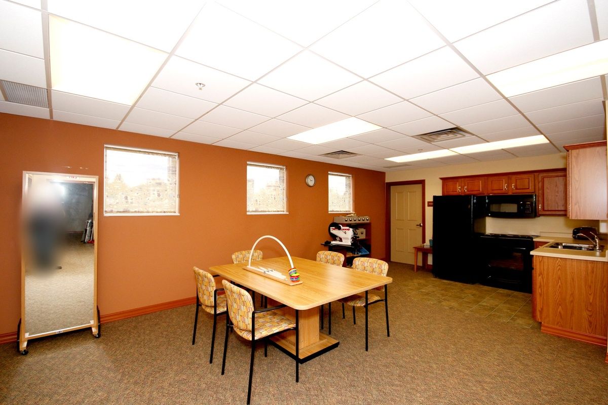A well-lit conference room with a table and chairs, featuring warm-colored walls.