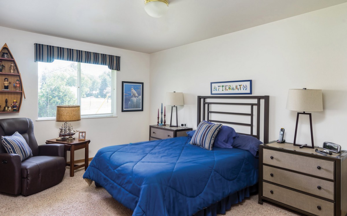 A cozy bedroom featuring blue bedding and complementary decor.