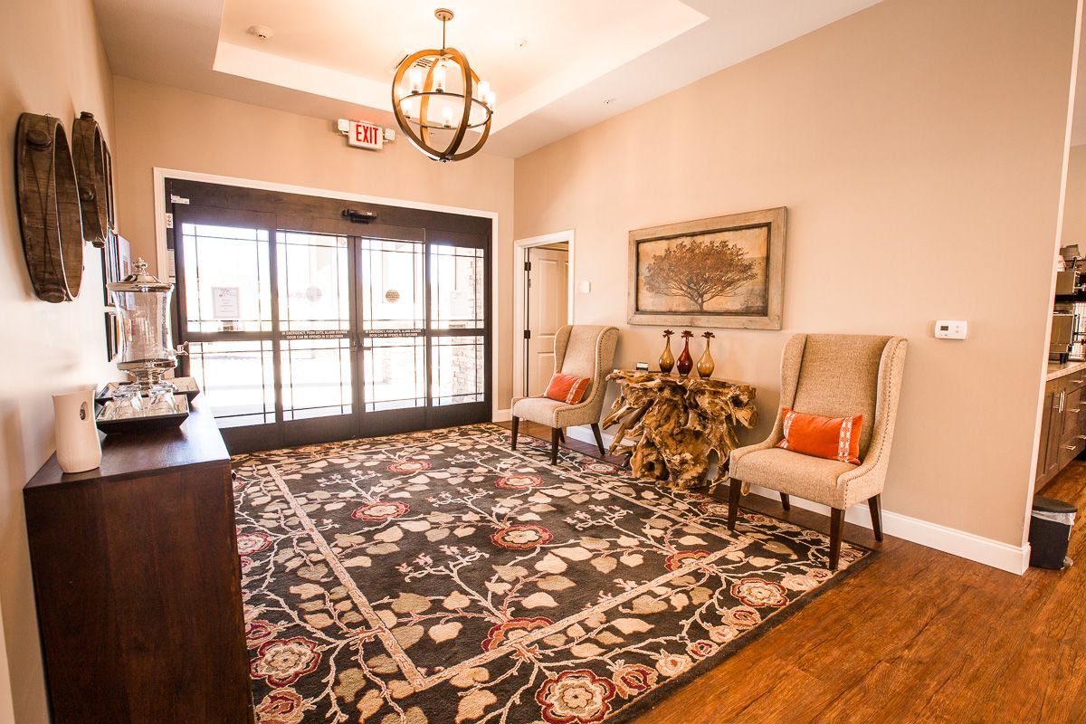 A welcoming lobby area featuring elegant chairs, a decorative rug, and tasteful artwork.
