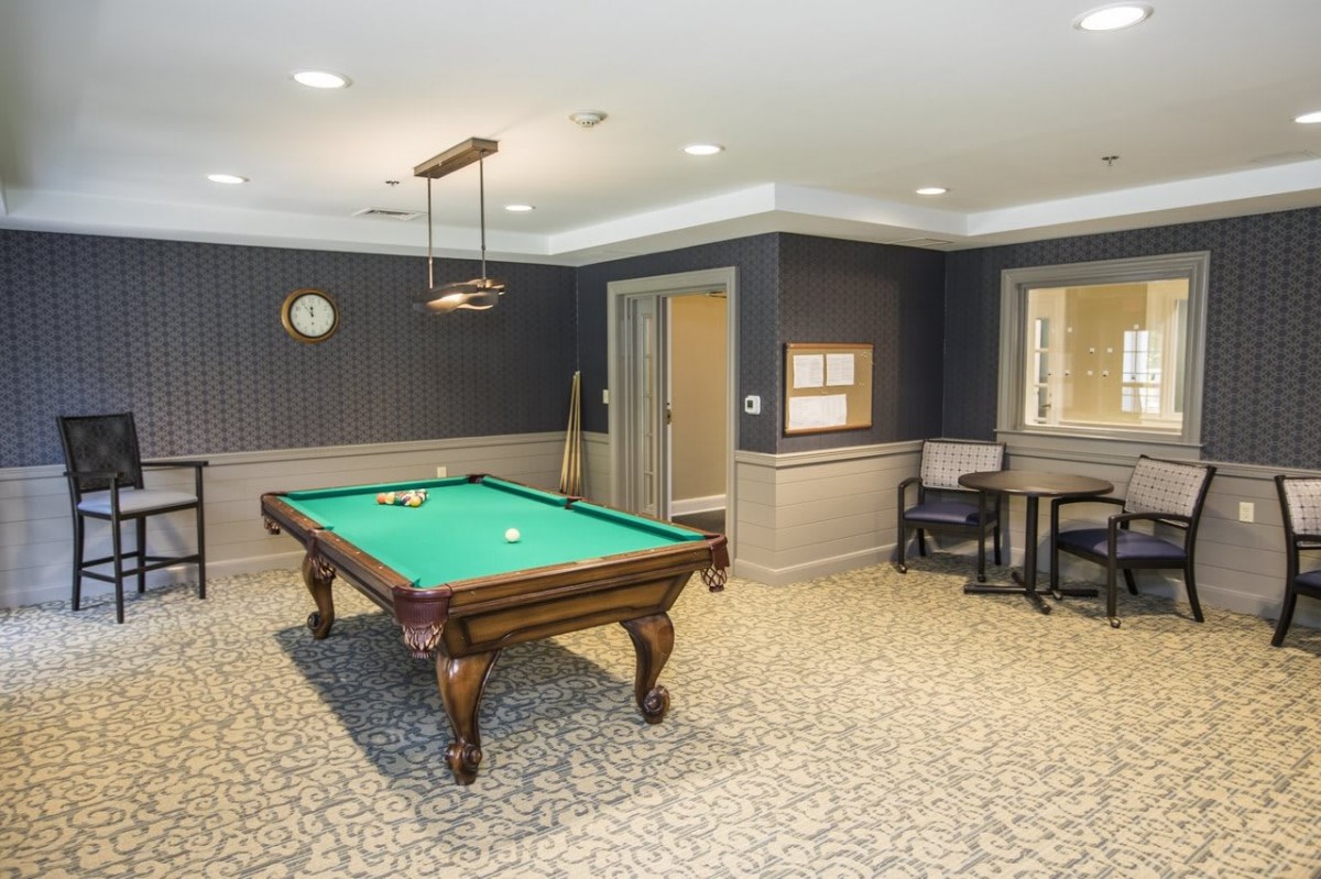 A well-furnished game room with a pool table and seating area.