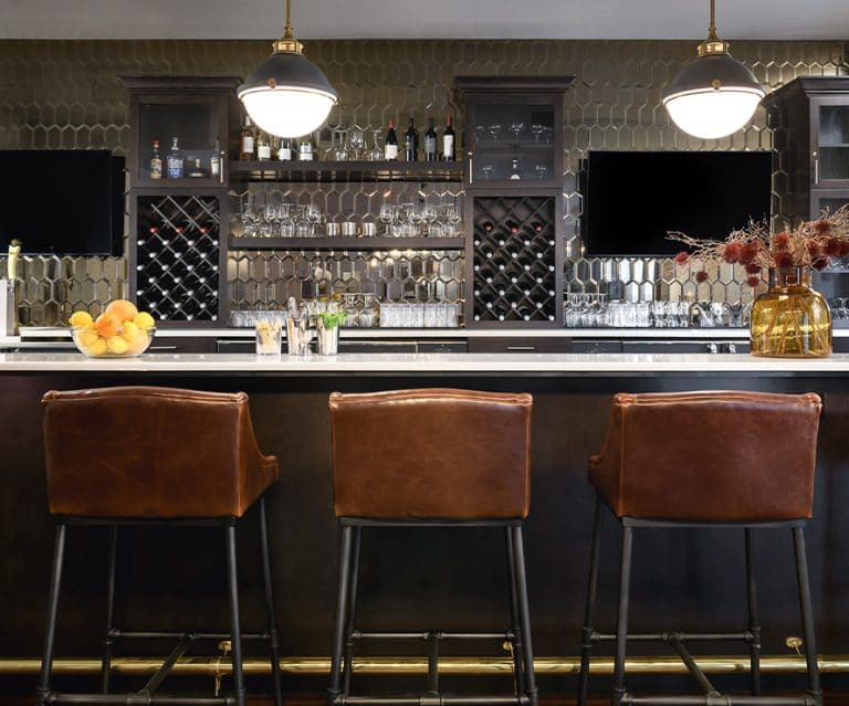 A stylish bar interior with leather stools and a well-stocked counter.
