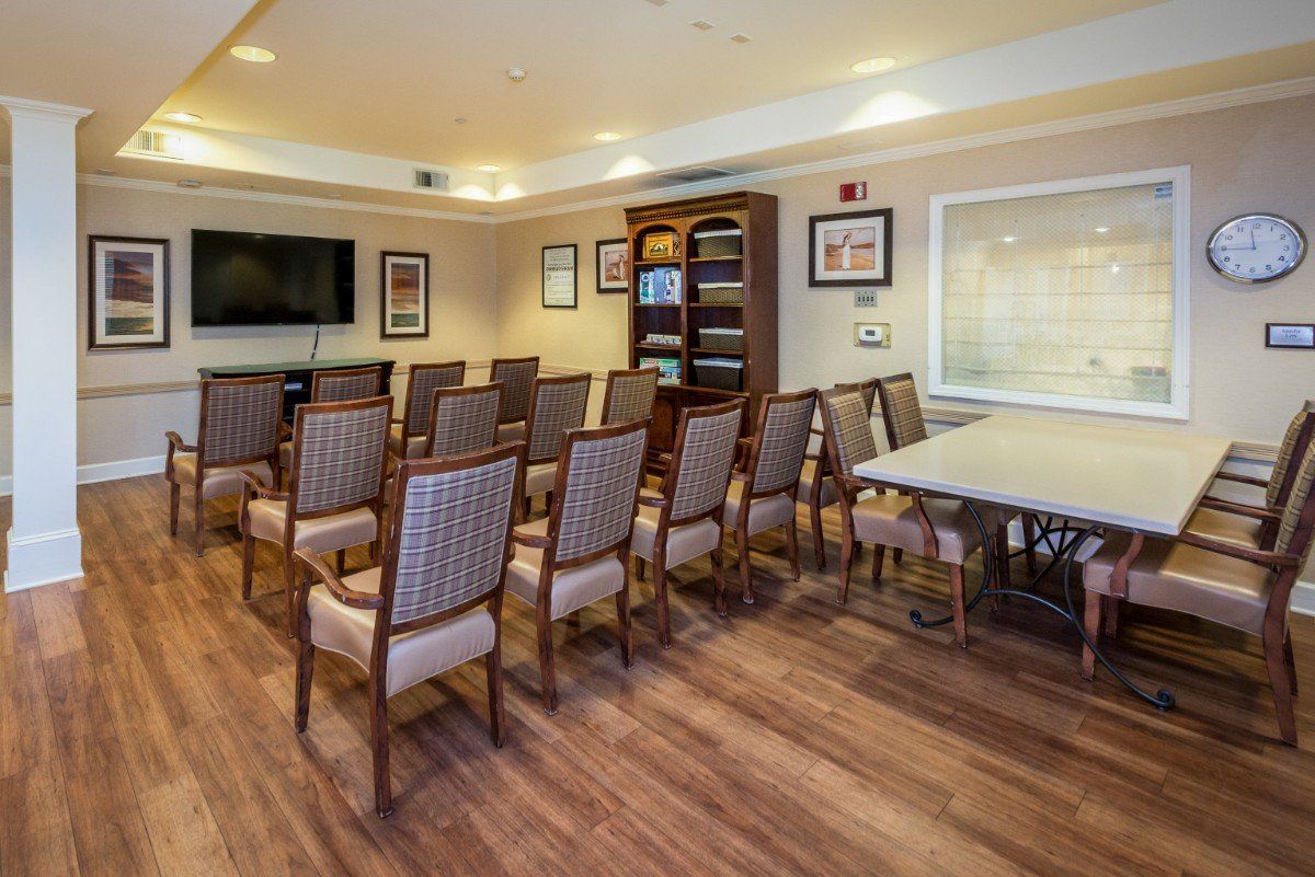 A neatly arranged conference room with chairs facing a television, ready for a presentation or meeting.