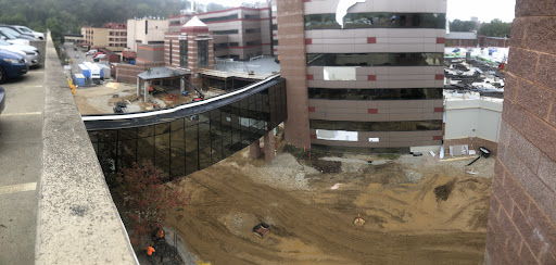 A view of a construction site featuring modern buildings and a connecting bridge.