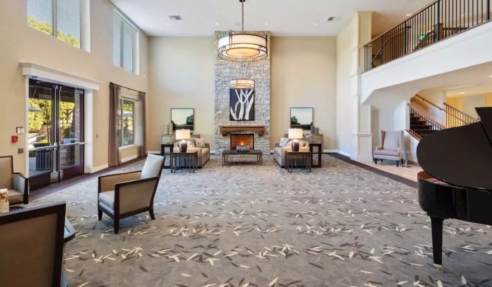A spacious lobby with a cozy seating area, chandelier, and fireplace.