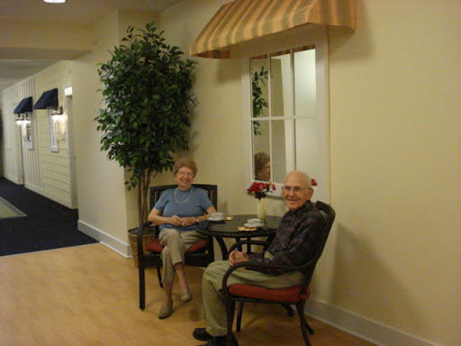 Two elderly individuals enjoying their time in a cozy lounge area.