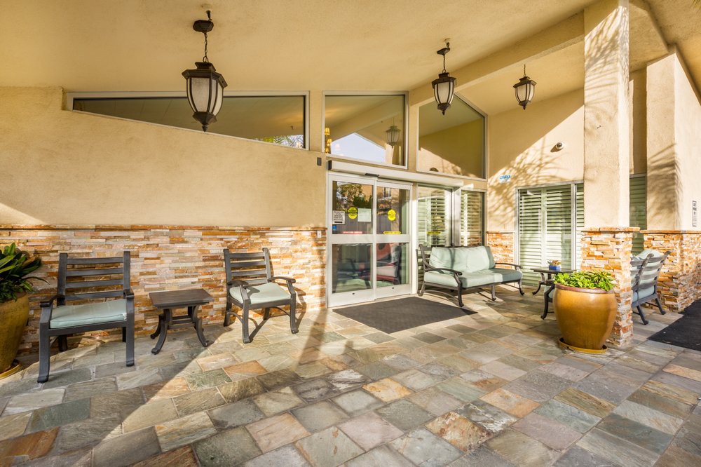 A welcoming entrance with outdoor seating and decorative lanterns.