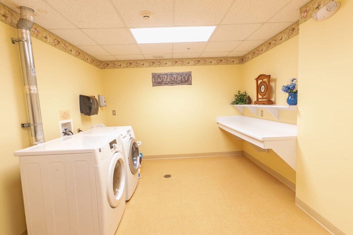 A clean and neatly organized laundry room with washing machines and a folding table.
