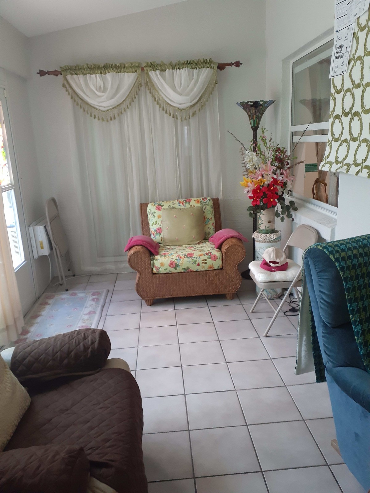 A cozy living room setup with an armchair, decorative curtains, and a lamp.