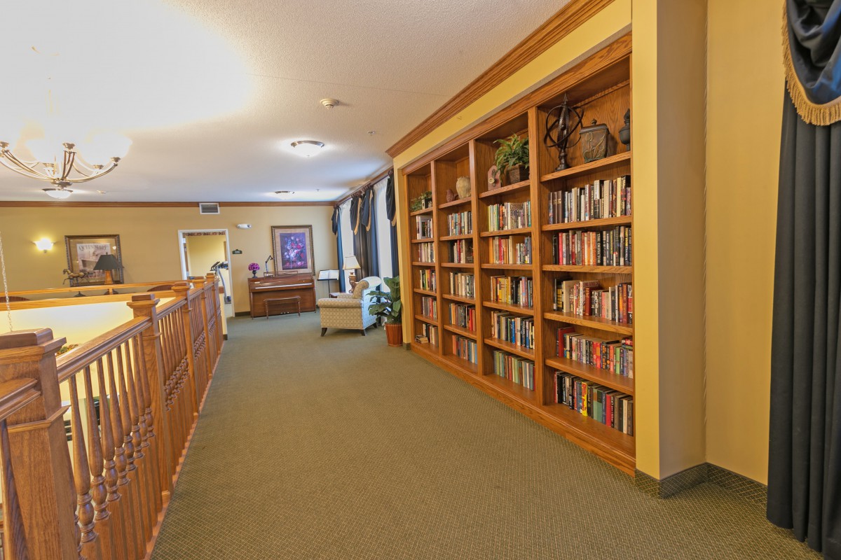 A cozy library hallway with wooden bookshelves filled with books.