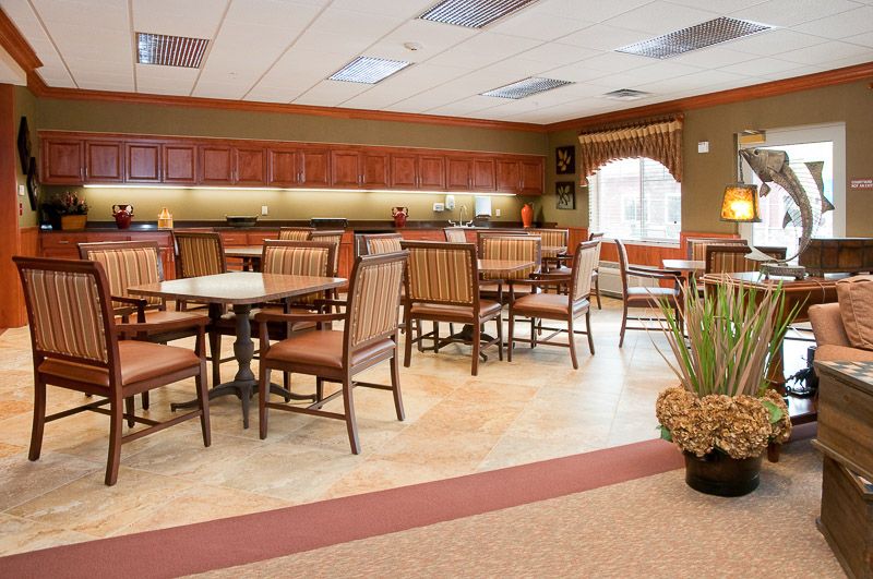 A clean and well-organized dining area with wooden chairs and tables.