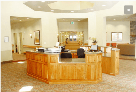 A well-lit reception area with wooden furniture and office equipment.