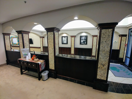 A modern reception area featuring elegant design with artwork and furniture.