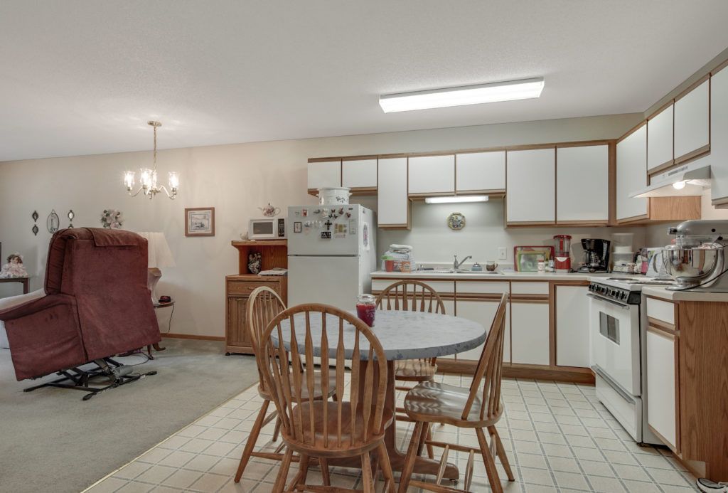 A cozy kitchen with a dining area featuring a table, chairs, and basic appliances.