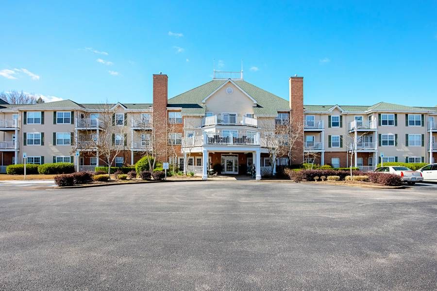The exterior of a hotel with a large entrance and multiple windows against a clear blue sky.