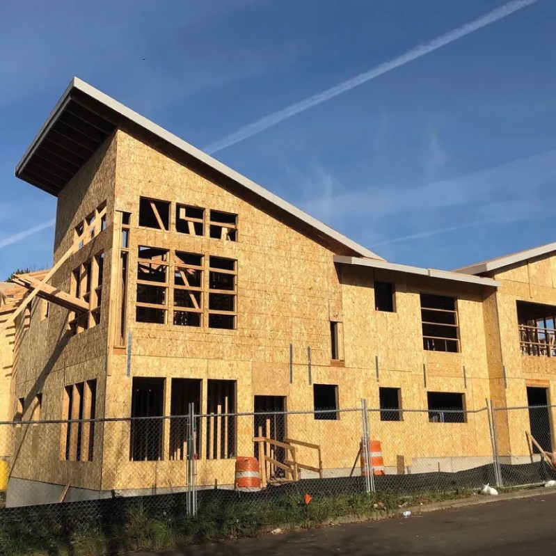 A residential building in the process of construction with a wooden framework and modern architectural design.