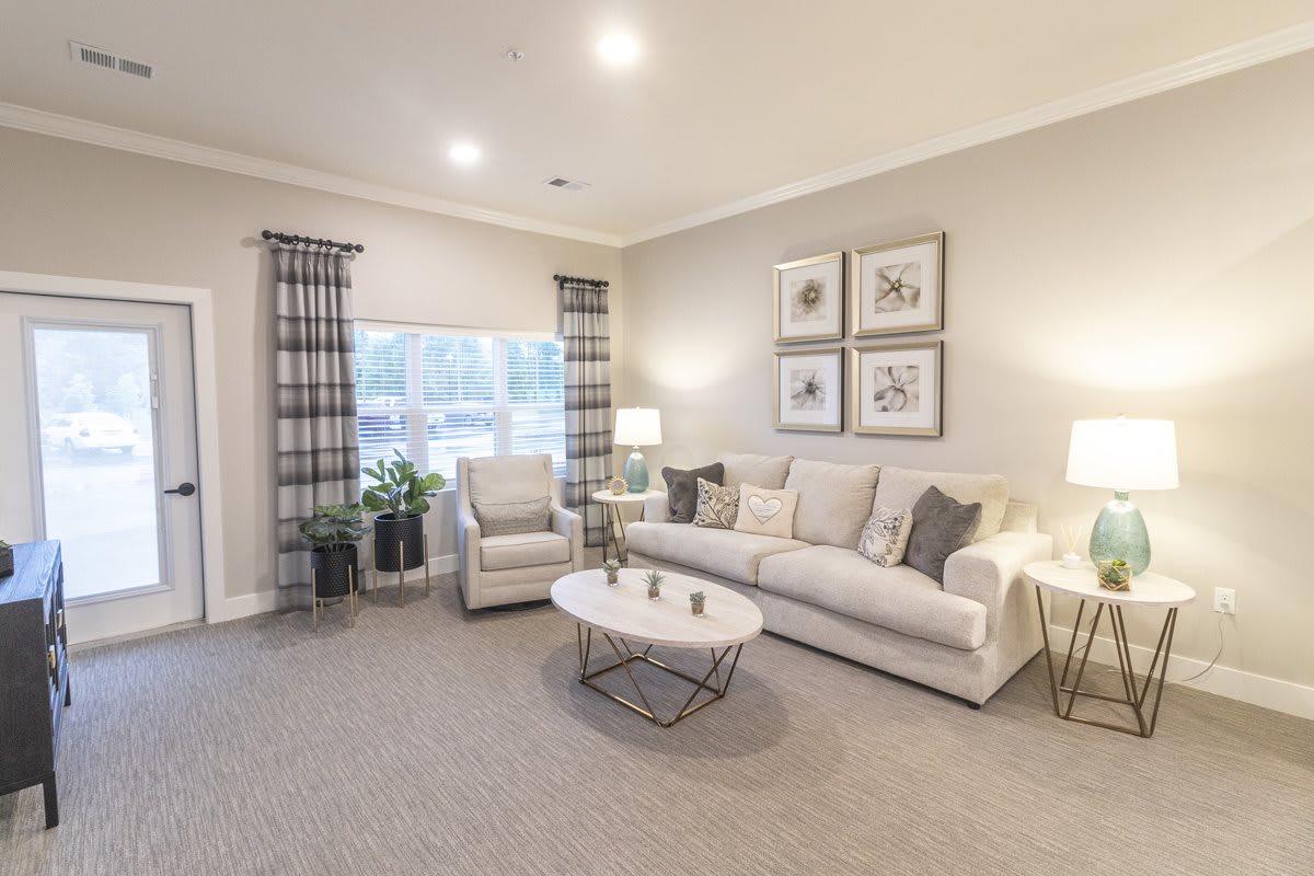 A cozy living room with modern decor, featuring a sofa, armchair, and coffee table.