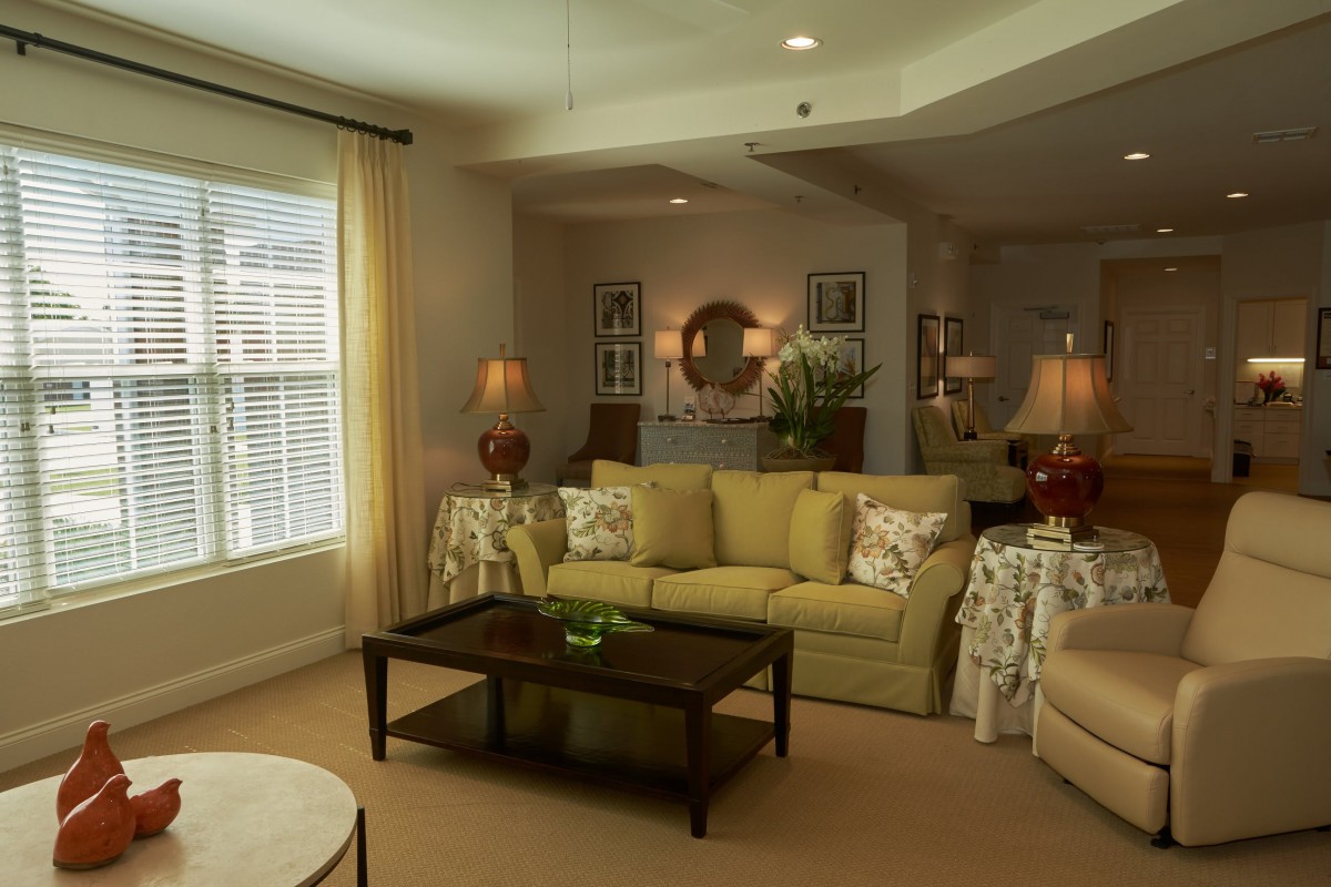A cozy living room with stylish decor, featuring a sofa, coffee table, and elegant lighting.