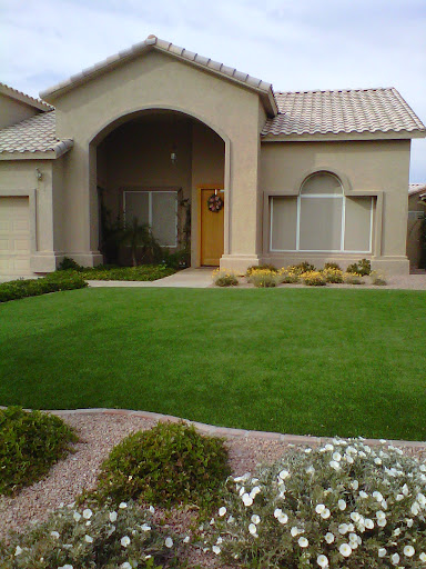 A well-maintained residential home with a lush front lawn and landscaped garden.