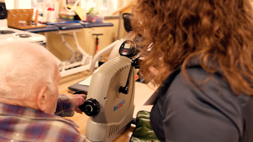 A close-up of a patient using an eye examination device in a healthcare environment.