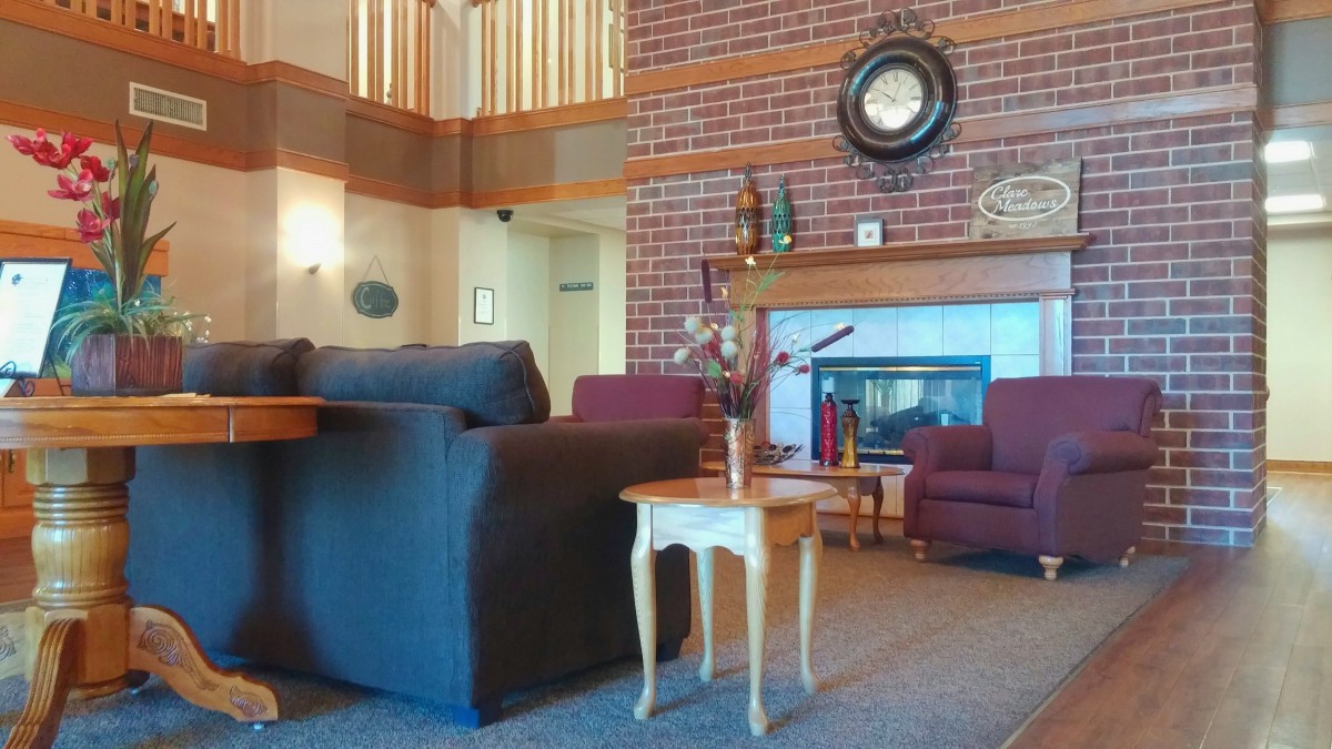 A cozy living room with a brick fireplace, comfortable seating, and warm decor.