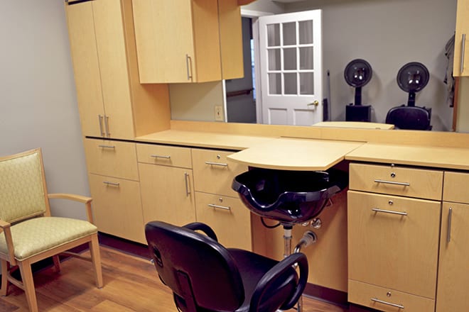 A well-equipped hair salon interior with a chair and sink.
