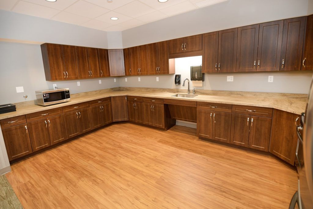 A modern kitchen with wooden cabinets, countertops, and wood flooring.