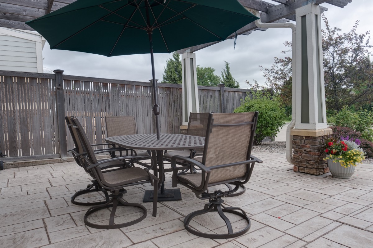 A cozy patio setup with a round table, chairs, and a large umbrella.
