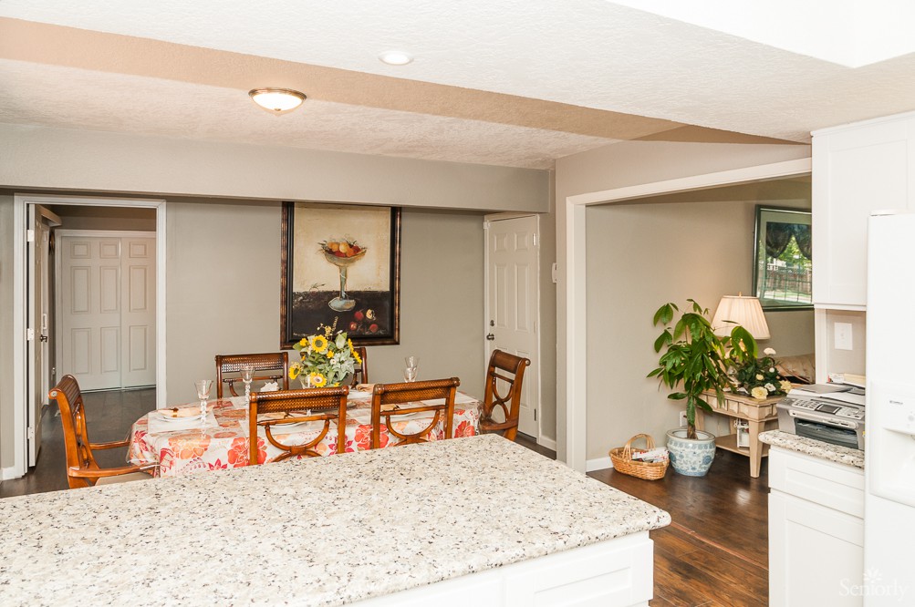 A cozy dining area with a table set for a meal and decorative elements including flowers and plants.
