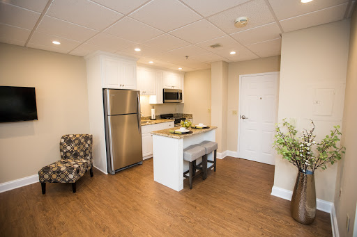 A modern kitchen and living space featuring sleek appliances and cozy seating.