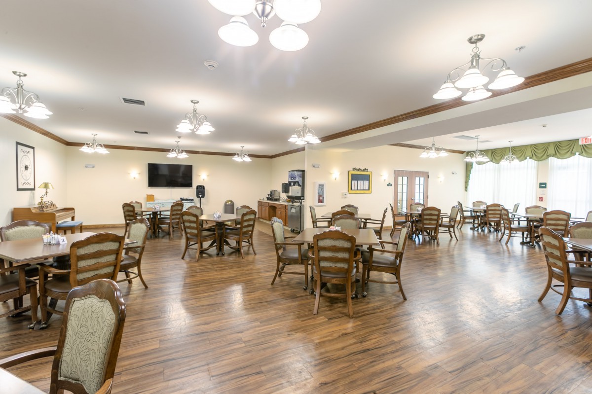 A spacious dining area with wooden tables and chairs, well-lit and decorated.