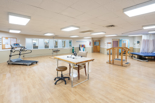 A spacious physical therapy room equipped for rehabilitation exercises.