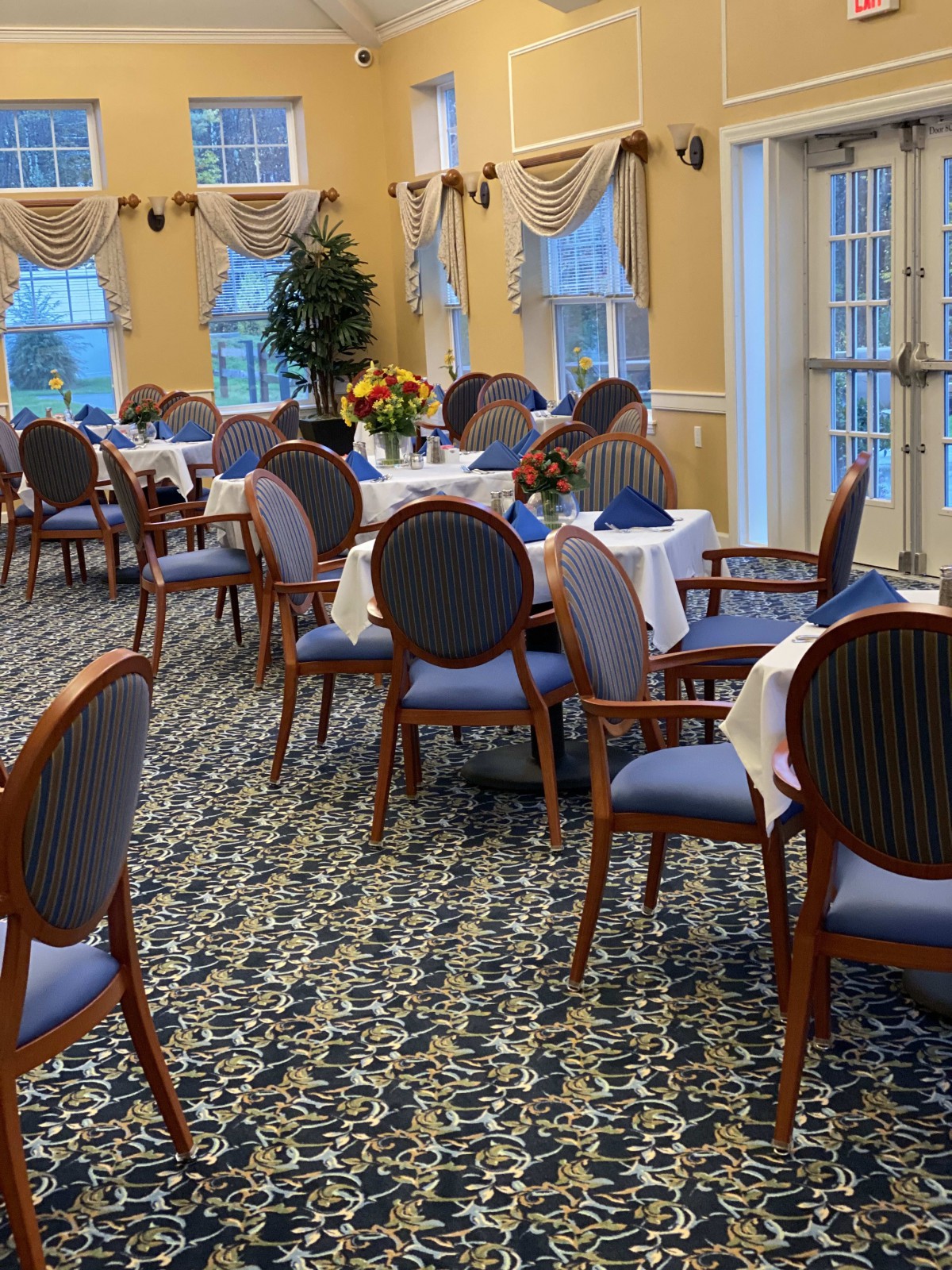 An elegant dining room with neatly arranged tables and chairs, featuring a stylish interior design.