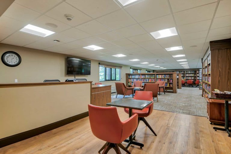 A modern library interior with seating and bookshelves.