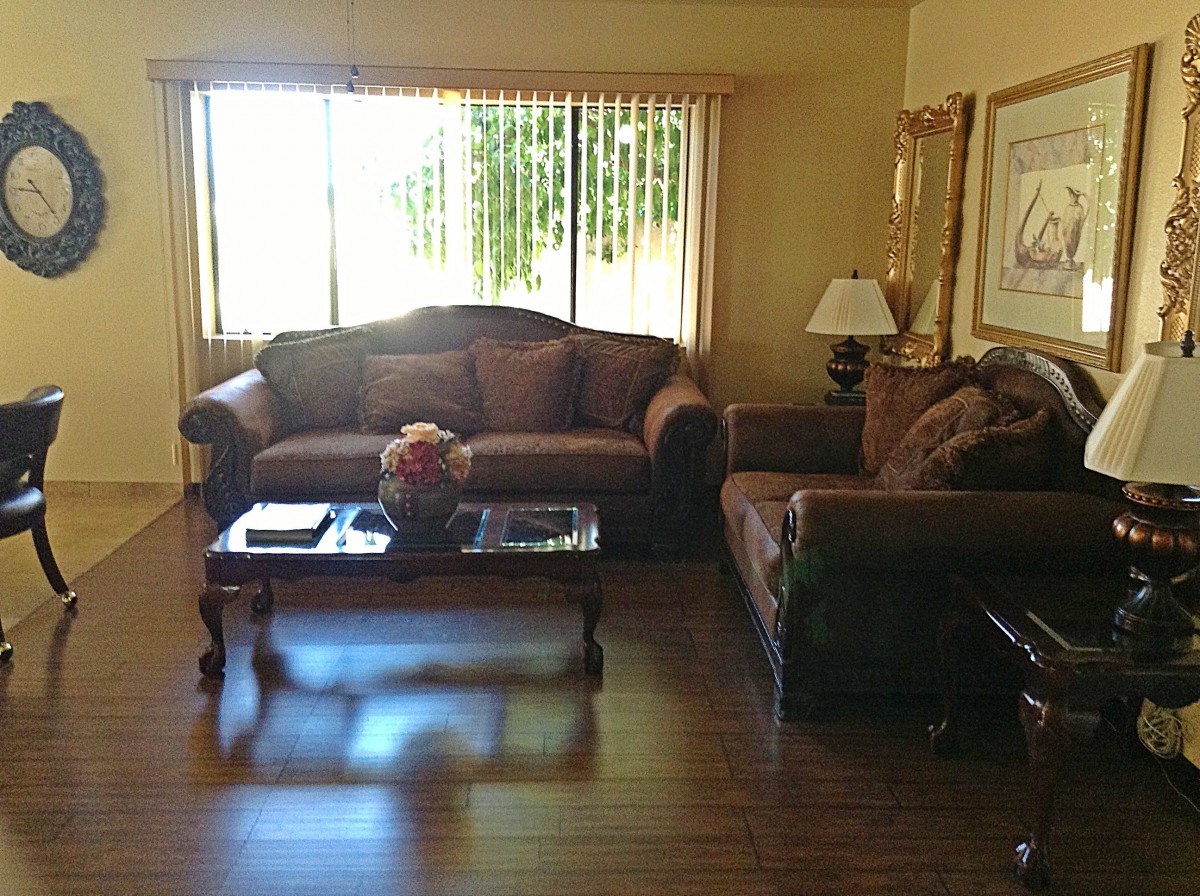 A cozy living room with two sofas, a coffee table, and a lamp by the window.