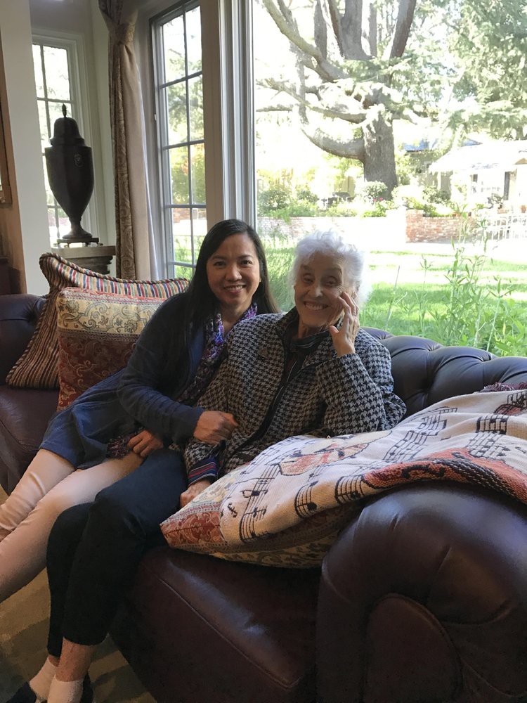 Two people sitting on a couch in a cozy living room.