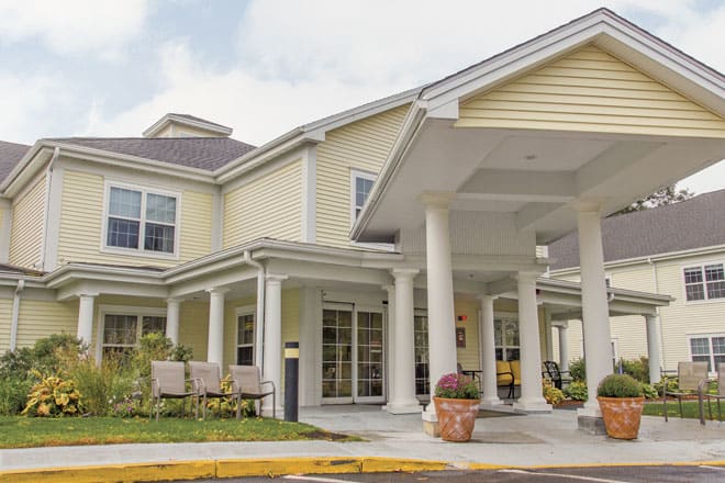 A residential building with a covered entrance and decorative columns.