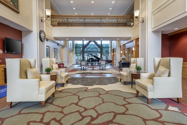 A luxurious hotel lobby featuring elegant seating and a grand piano.