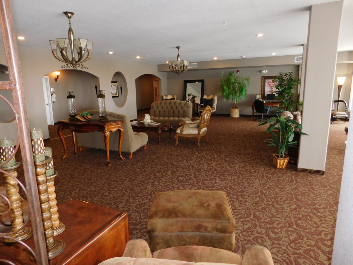 A spacious lobby with comfortable seating, elegant chandeliers, and decorative plants.