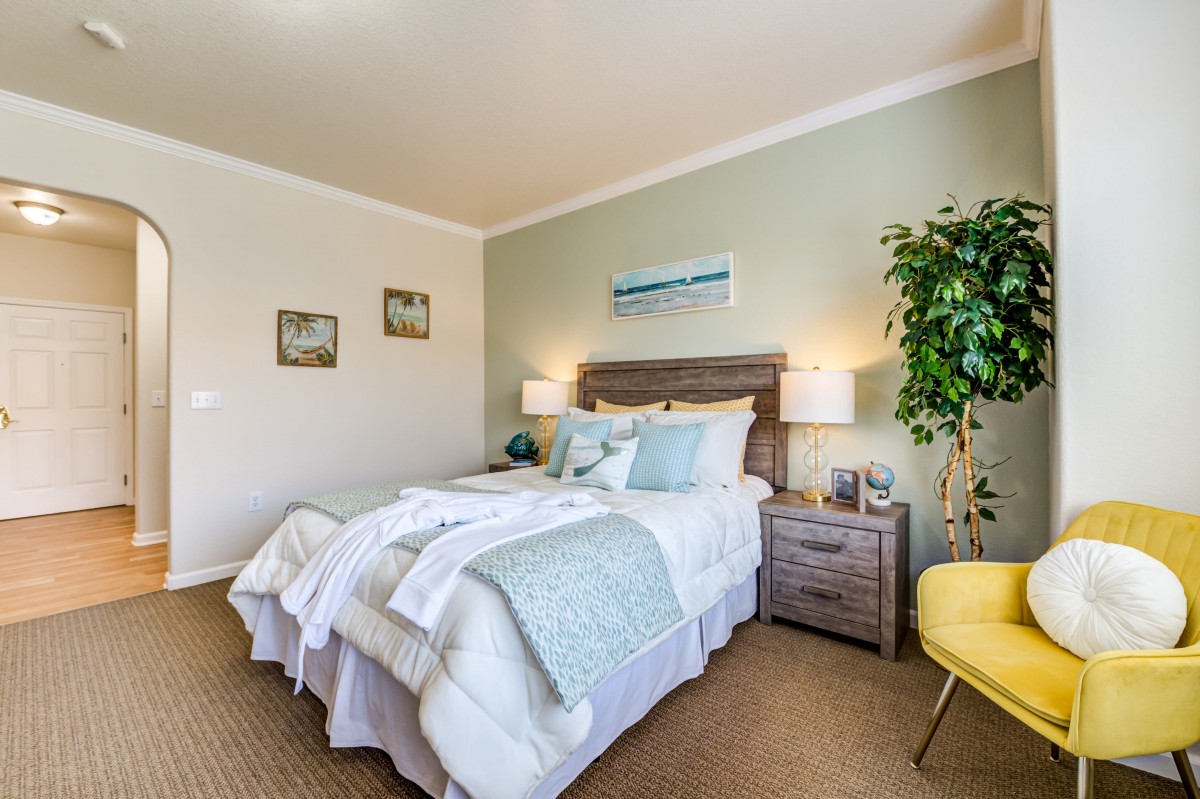 A cozy, modern bedroom with a neatly made bed, stylish decor, and soft lighting.