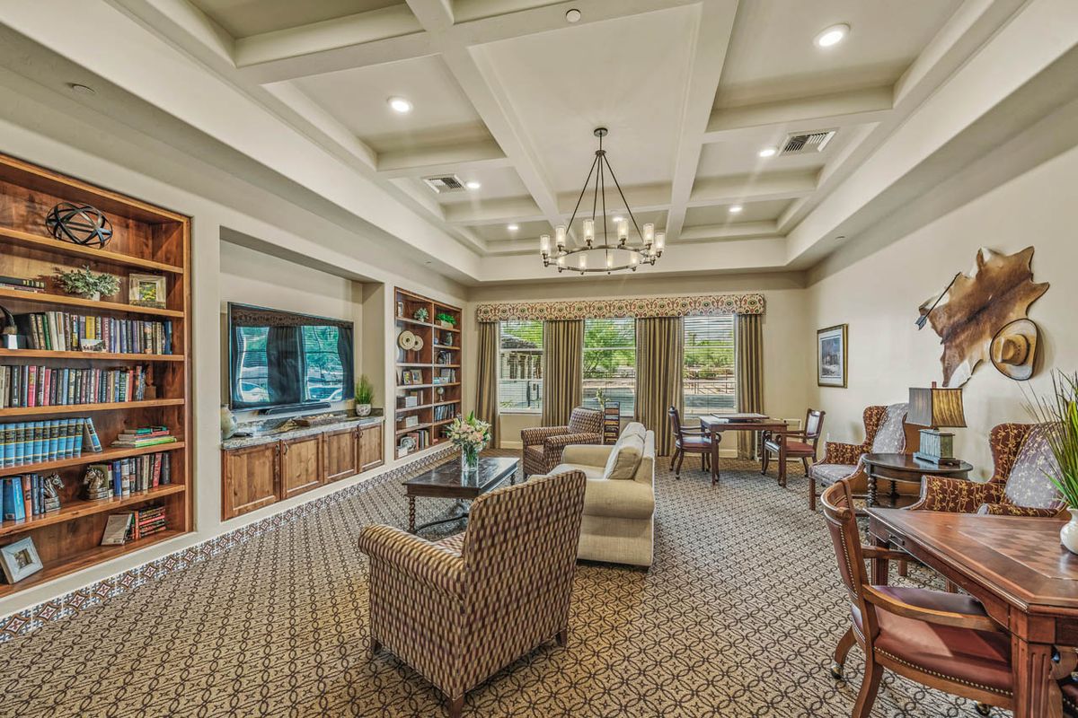 A cozy living room with bookshelves, a comfortable sofa, and a chandelier.