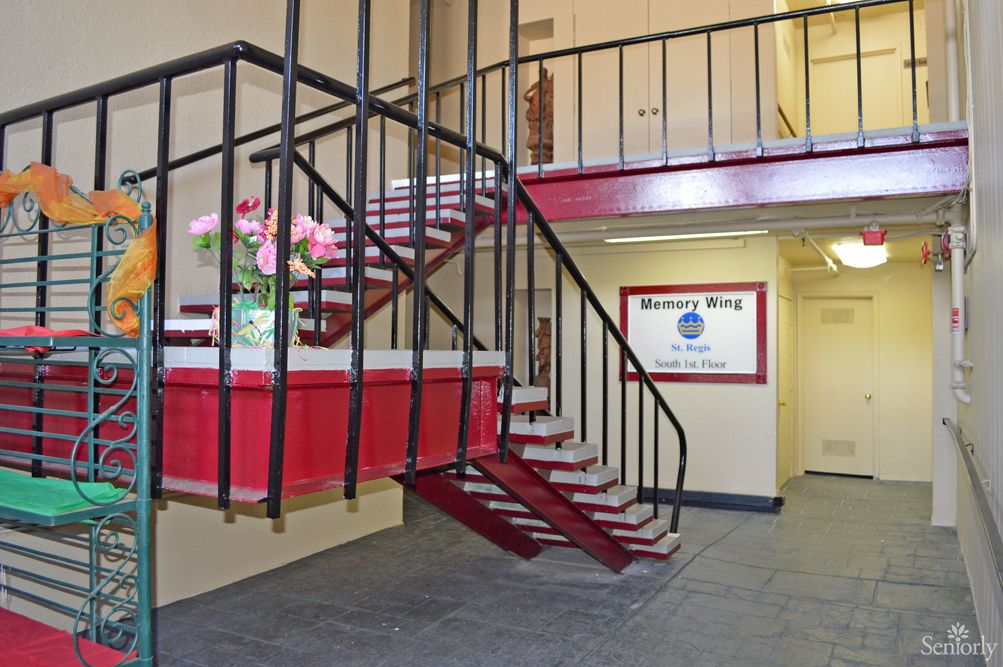 Interior view of a building entrance with a staircase and decorative flowers.