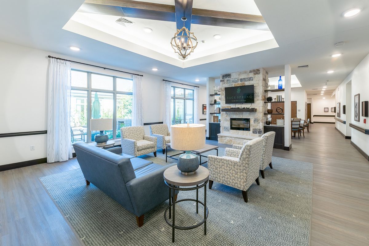A modern living room with comfortable seating, a fireplace, and large windows allowing natural light.