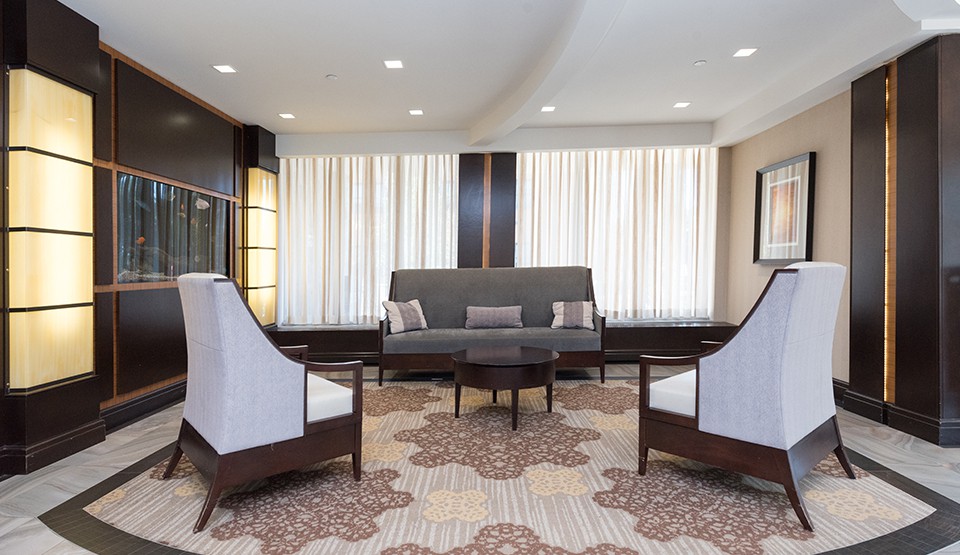 A stylish and modern living room interior with a sofa, chairs, coffee table, and patterned carpet.