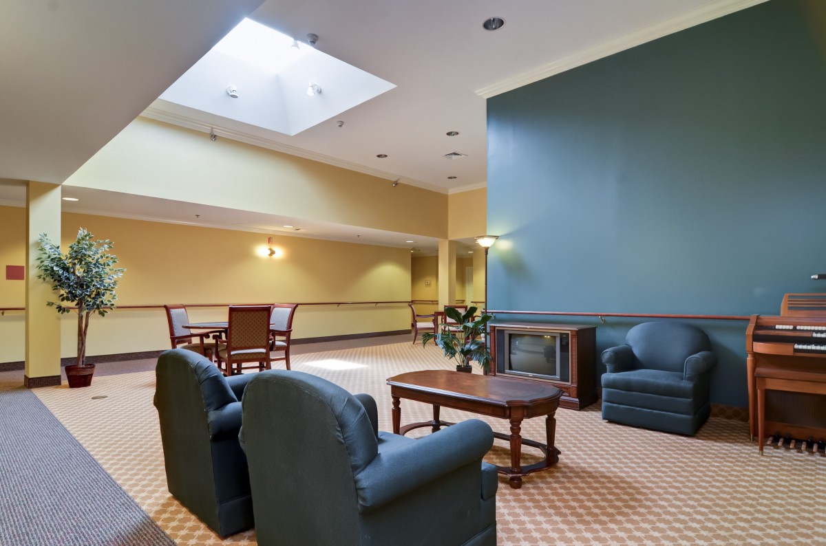 A cozy lobby area featuring comfortable seating, a skylight, and warm lighting.