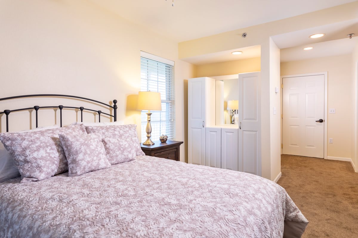 A cozy bedroom interior with a neatly made bed and soft lighting.