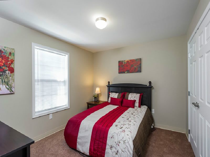 A cozy bedroom with a neatly made bed and warm lighting.